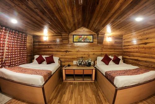 Habitación con 2 camas en una cabaña de madera en Goroomgo Broadway Anexy Darjeeling Near Mall Road - Best Service Awarded, en Darjeeling