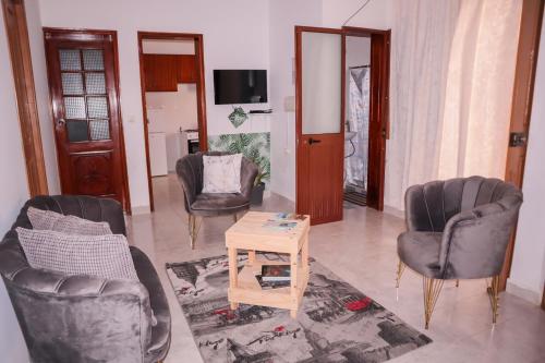 a living room with three chairs and a table at Escape House in Tarrafal