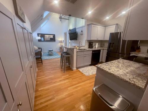 a kitchen with white cabinets and a wooden floor at Modern, Newly Renovated 3bed, 2bath, Steps To Mbta in Boston