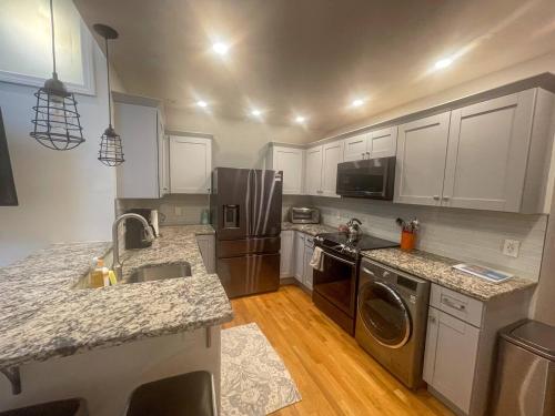 a kitchen with a sink and a dishwasher at Modern, Newly Renovated 3bed, 2bath, Steps To Mbta in Boston