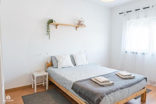 a bedroom with a bed with two towels on it at By Santa in Santa Cruz
