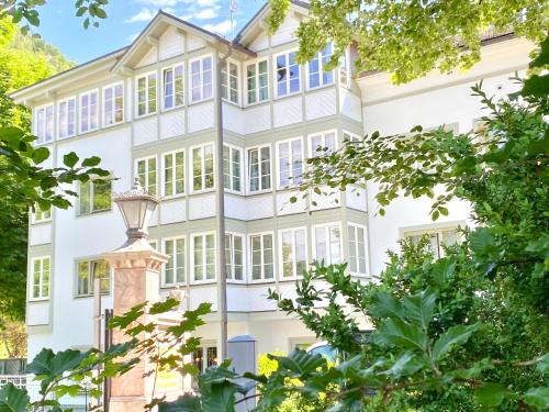 una vista exterior de una casa blanca con árboles en Boutiquehotel Hubertushof, en Bad Ischl