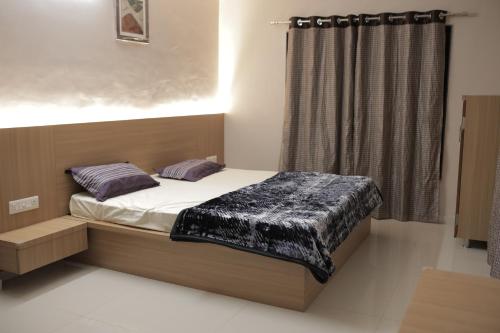 um pequeno quarto com uma cama e uma janela em Kookee Villa em Hātgarh