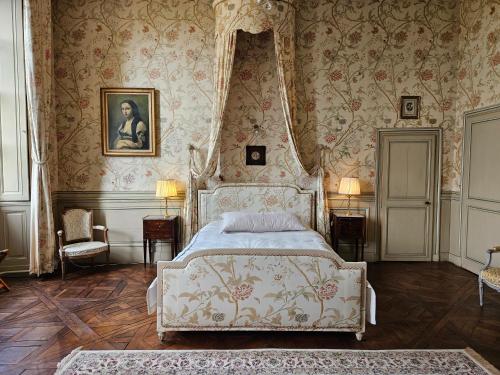 una camera con un letto in una stanza con carta da parati di Château de Craon a Craon