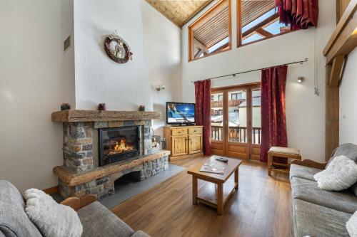 un salon avec une cheminée et un canapé dans l'établissement Les Suites du Val Claret by ExplorHome, à Tignes