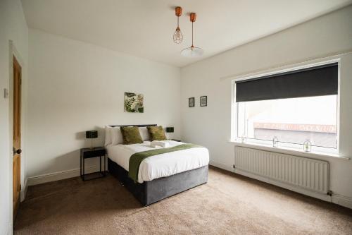 a white bedroom with a bed and a window at Jubilee House By Horizon Stays in Eston