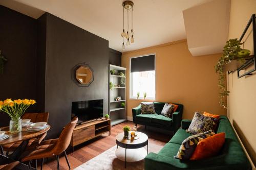 a living room with a green couch and a table at Jubilee House By Horizon Stays in Eston