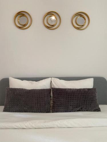 a wall with three lights above a bed with pillows at Almada Central Apartment in Almada