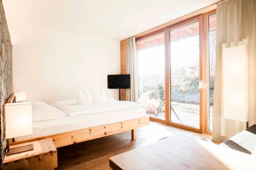 1 dormitorio con cama y ventana grande en Steindls Boutique Favourite, en Vipiteno