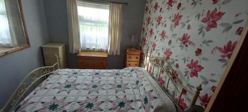 a bedroom with a bed with a floral bedspread at Sundowner 3 Bed Chalet in Hemsby Great Yarmouth in Great Yarmouth