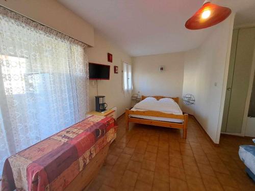 une chambre avec deux lits et une fenêtre dans l'établissement Studio cosy 4 pers avec terrasse, parking sécurisé, proche commerces à Marseillan - FR-1-326-591, à Marseillan