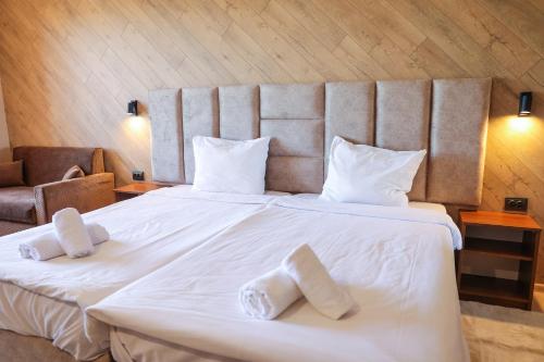 a large white bed with two white towels on it at Family Hotel Gotse Delchev in Gotse Delchev