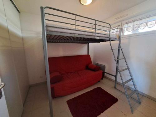 Cette chambre comprend une mezzanine avec un canapé rouge. dans l'établissement Appartement T2 front de mer avec terrasse et parking privé - FR-1-326-445, à Marseillan