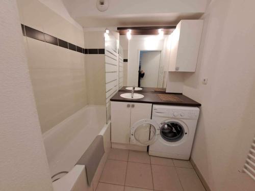 une petite salle de bains avec un lave-linge et un lavabo dans l'établissement Appartement T2 front de mer avec terrasse et parking privé - FR-1-326-445, à Marseillan