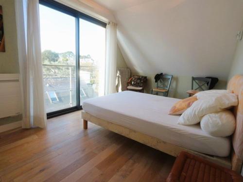 a bedroom with a bed and a large window at Bénodet, appart. 3*, plage à pied, parking privé - FR-1-481-52 in Bénodet