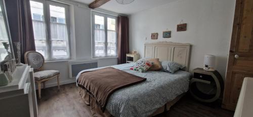 - une chambre dotée d'un lit avec une personne assise dans l'établissement Vue d'ici, à Saint-Valery-sur-Somme