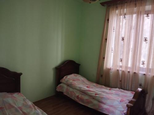 a bedroom with a bed and a window with curtains at Севан 3 Ветерок in Sevan