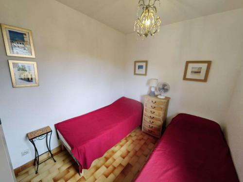 - une chambre avec 2 lits rouges et une commode dans l'établissement T3 avec Terrasse, Piscine, Tennis et Parking Privé à 100m de la Plage - FR-1-607-1, au Cap d'Agde