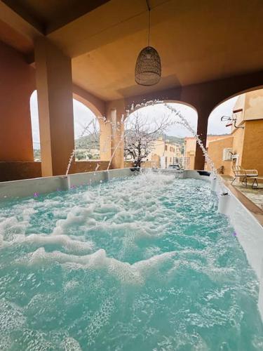 une grande piscine d'eau dans un bâtiment dans l'établissement Authentique appartement vue montagnes avec grand patio et jacuzzi chauffé, à Santa-Reparata-di-Balagna
