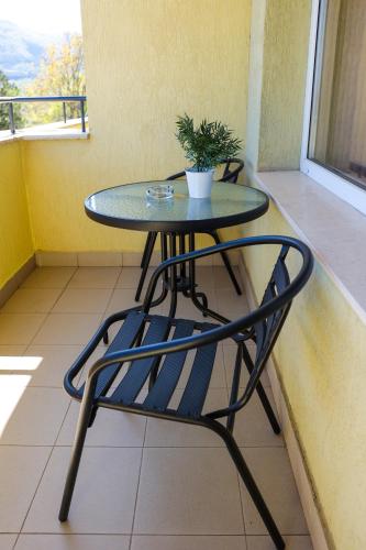 a table and a chair on a balcony at Family Hotel Gotse Delchev in Gotse Delchev