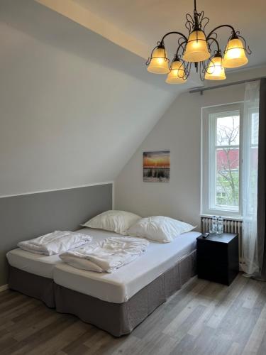 a bedroom with a bed and a chandelier at Villa Garden Island in Berlin
