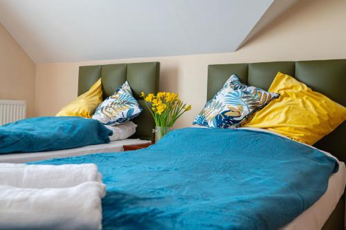 a bedroom with two beds with blue and yellow pillows at Noclegi Junior Wągrowiec in Wągrowiec