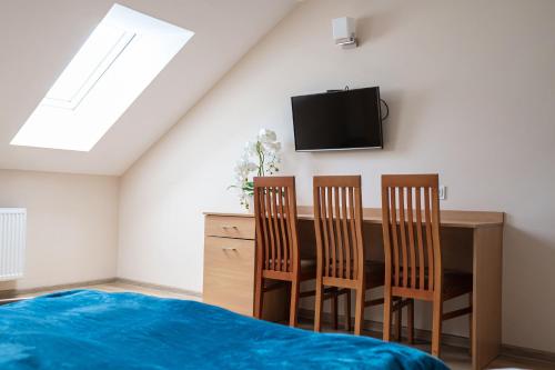 a bedroom with a table and chairs and a tv at Noclegi Junior Wągrowiec in Wągrowiec