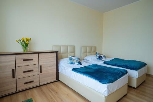 two twin beds in a room with a dresser at Noclegi Junior Wągrowiec in Wągrowiec