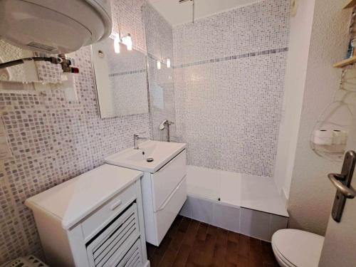 une salle de bain blanche avec un lavabo et des toilettes dans l'établissement Studio en Rez-de-Chaussée avec Terrasse Spacieuse et Parking Privé à Marseillan - FR-1-326-814, à Marseillan