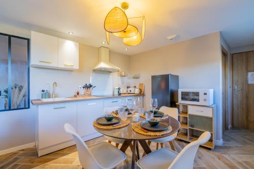 une cuisine et une salle à manger avec une table et des chaises dans l'établissement La Parenthèse en Provence - Appt Balnéothérapie, à Roquefort-la-Bédoule