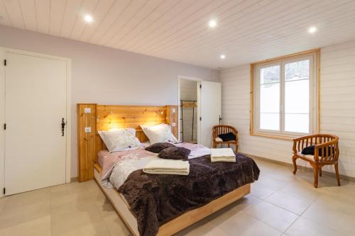 une chambre avec un grand lit et deux chaises dans l'établissement Le Cèrvi - Station de ski à pied, à Ax-les-Thermes