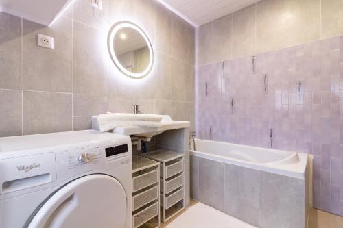 une salle de bain avec une machine à laver et un lavabo dans l'établissement Le Cèrvi - Station de ski à pied, à Ax-les-Thermes
