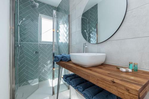 ein Bad mit einem Waschbecken, einer Dusche und einem Spiegel in der Unterkunft Villa luxe - St Paul - Piscine - A/C in Saint-Paul-de-Vence