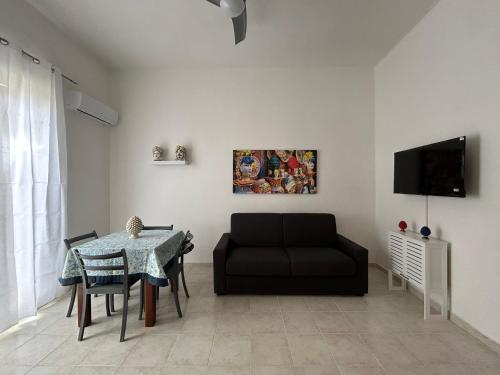 a living room with a black couch and a table at Le Trottole Apartment in Palermo