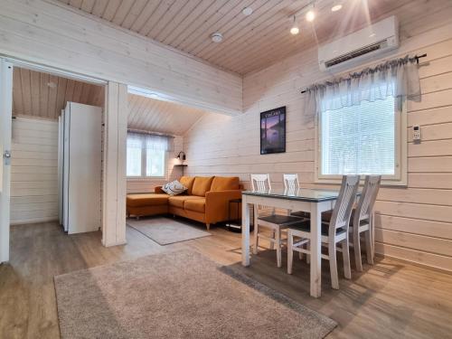 a living room with a table and a couch at Holiday Resort Harjun Portti in Punkaharju