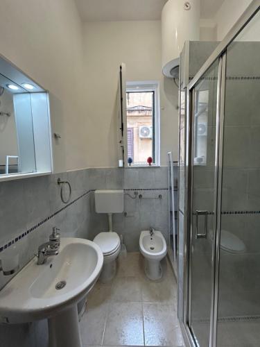 a bathroom with a sink and a toilet and a shower at Le Trottole Apartment in Palermo