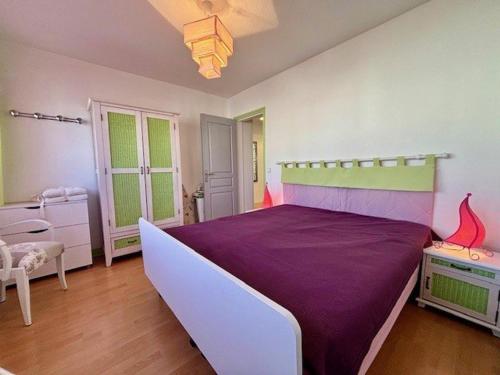 une chambre avec un grand lit avec des draps violets dans l'établissement Quiberon - Superbe 3 pièces tout confort face mer - 5 pers - 63m² - Proche plage et centre-ville - FR-1-478-275, à Quiberon