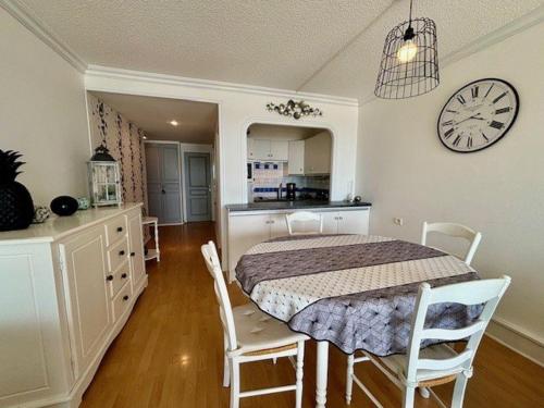 une salle à manger avec une table et une horloge au mur dans l'établissement Quiberon - Superbe 3 pièces tout confort face mer - 5 pers - 63m² - Proche plage et centre-ville - FR-1-478-275, à Quiberon