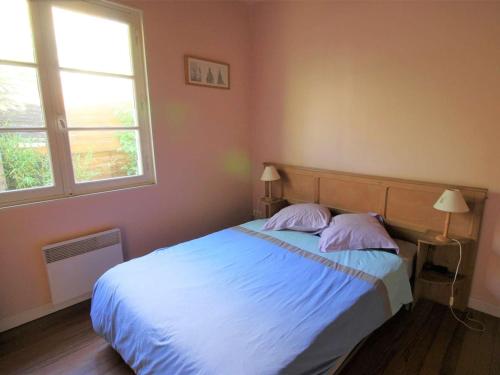 - une chambre avec un lit avec deux oreillers et deux fenêtres dans l'établissement Villa lumineuse à 300m de la plage, 5min de l'océan en vélo, jardin et terrasse, proche commerces - FR-1-736-1, à Lège-Cap-Ferret