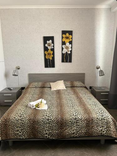 a bedroom with a bed with three pictures on the wall at Raggio di Sole in San Cesareo