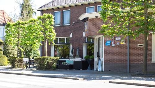 un edificio de ladrillo con un patio delante de él en Hotel Bi-j Ons en Lichtenvoorde