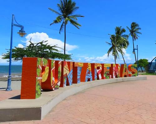 Ein Zaun mit einem Schild, das Melaka am Strand liest. in der Unterkunft Hostel del Pacífico in Puntarenas