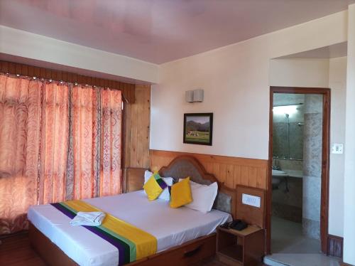 a bedroom with a bed and a window at Hotel Rajat in Shimla