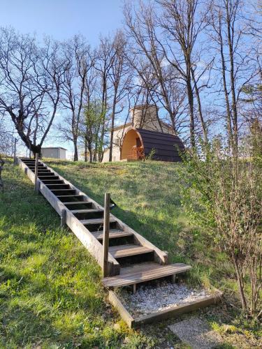 a wooden stairs leading up to a field with a barn at Camping du Moulin de Thoard in Thoard