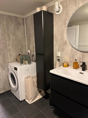 a bathroom with a washing machine and a sink at Nordbyhuset, et trivelig fritidshus in Skudeneshavn