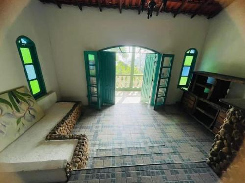 a room with an open door and a room with a couch at Pousada e Hostel Vida no Paraiso in Angra dos Reis