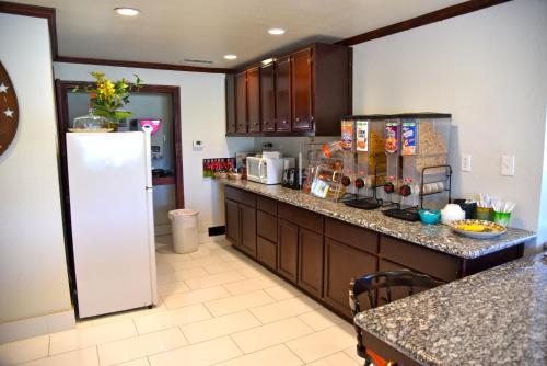 a kitchen with a refrigerator and a counter top at Purple Sage Motel in Snyder