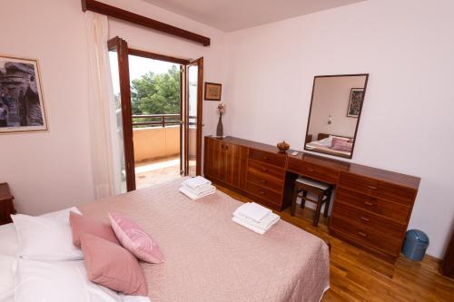 een slaapkamer met een bed met roze kussens en een spiegel bij 4u2enjoy in Split