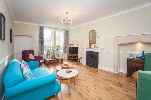 a living room with a blue couch and a fireplace at Georgian Garden Apartment - Central Bath in Bath