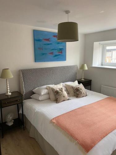 a bedroom with a bed with white sheets and pillows at Pretty cottage near Cirencester in Purton
